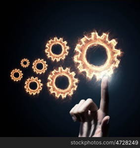 Cogwheel mechanism as teamwork concept. Business person hand touching gear mechanism representing interaction concept