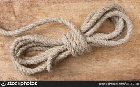 coil of hemp rope on old wooden background