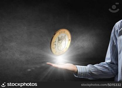 Coin in hand. Close up of businesswoman holding in palms euro coin