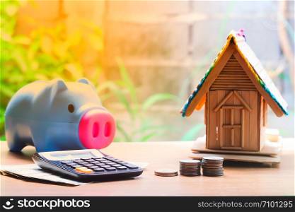 Coin stacks, house model, calculator and piggy bank, savings plans for housing