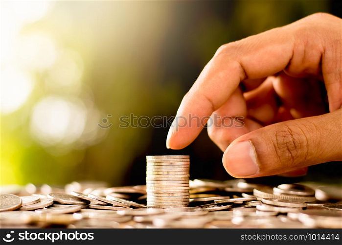 Coins are laid out while men&rsquo;s hands are gently touching. Whith a bokeh background and morning sunlight.