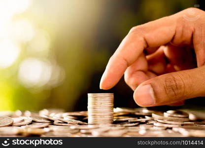 Coins are laid out while men&rsquo;s hands are gently touching. Whith a bokeh background and morning sunlight.