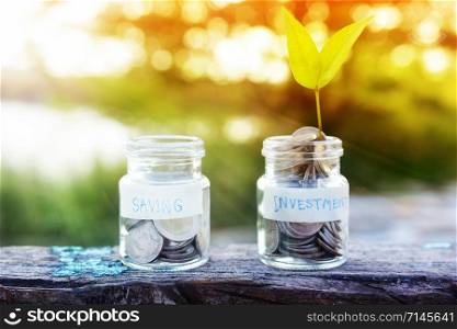 Coins money in Jar bottle on wood table sunlight nature green background,saving money concept