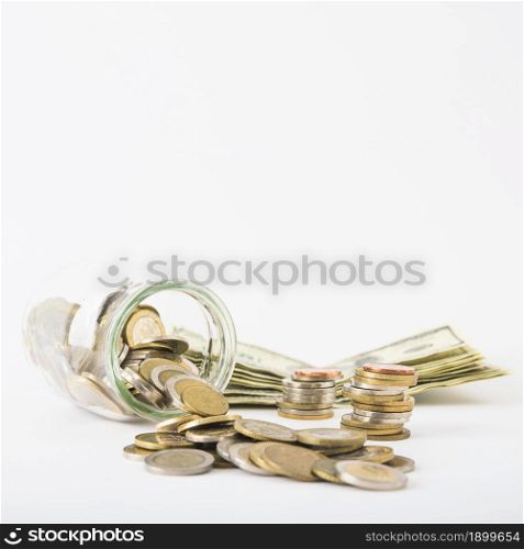 coins scattered from jar with paper money table. Resolution and high quality beautiful photo. coins scattered from jar with paper money table. High quality beautiful photo concept