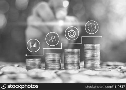 Coins stacked four rows with icons on the business growth, black and white tone.