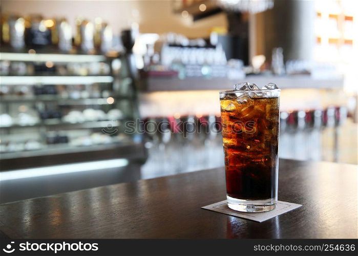 Cola on wood with restaurant background
