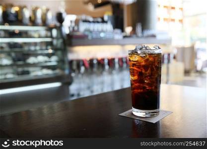 Cola on wood with restaurant background
