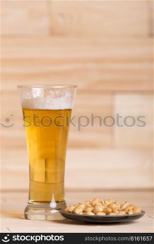 Cold beer with roasted peanuts, on wooden table, Still Life style