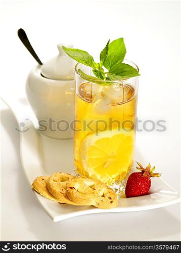 Cold black tea with lemon, ice and water drops on the glass surface