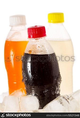 cold bottles of soda in ice on white background