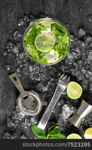 Cold cocktail with lime, mint, ice. Drink making tools and ingredients. Top view
