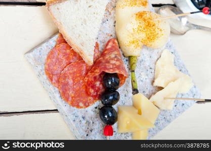 cold cut assortment cheese salami and fresh pears served on a granite stone