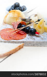 cold cut assortment cheese salami and fresh pears served on a granite stone