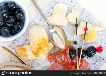 cold cut assortment cheese salami and fresh pears served on a granite stone