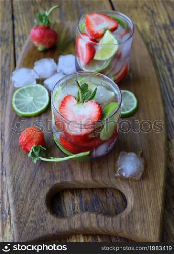Cold fresh lemonade drink with strawberry and lime close up .. Cold fresh lemonade drink with strawberry and lime close up