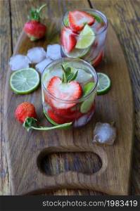 Cold fresh lemonade drink with strawberry and lime close up .. Cold fresh lemonade drink with strawberry and lime close up