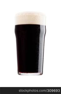 Cold glass of dark beer with foam and dew on white background with reflection