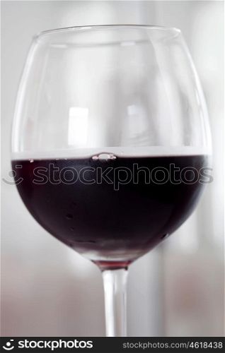 Cold glass of red wine by half