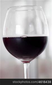 Cold glass of red wine by half