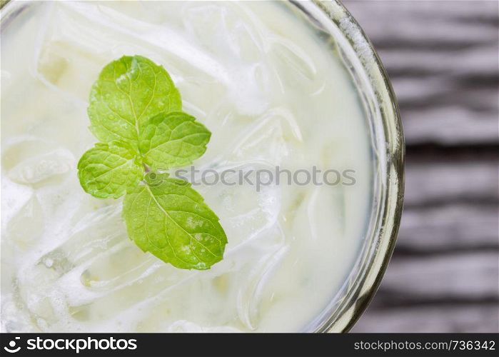 Cold Green Tea Milk Beverage or Cold Drinks Flatlay Left Frame. Green cold drinks and ice on wood table for drink