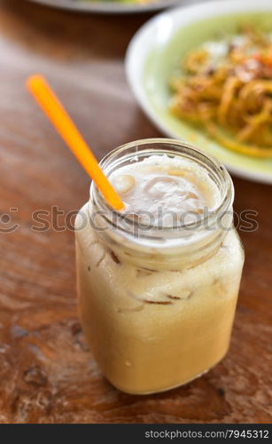 Cold ice coffee on wooden table in summer