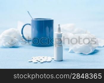 Cold illness medicaments, tea and tissues on blue background