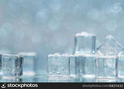 Cold melting ice cubes with water drops on blured background. Cold melting ice cubes with water drops