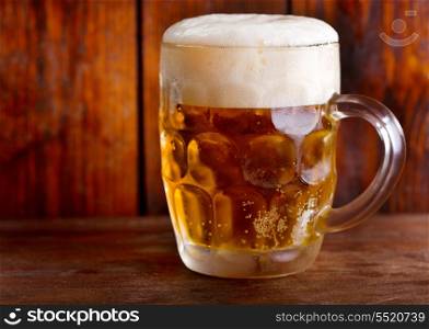 cold mug of beer on wooden table