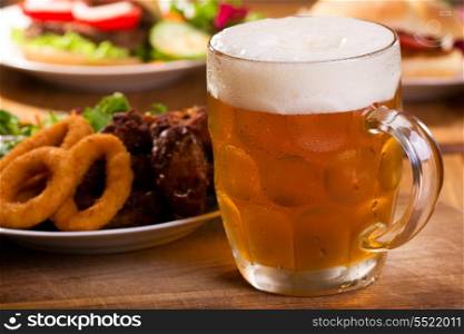 cold mug of beer with different snack