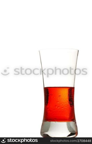 cold red drink. a glass filled with a cold red drink on white background