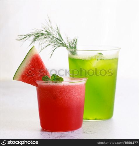 Cold refreshing drinks with watermelon and green cocktail in a glasses on white marble background.