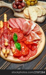 Cold smoked meat plate with pork chops, prosciutto, salami and bread sticks isolated on white background. Cold smoked meat plate with pork chops, prosciutto, salami and bread sticks