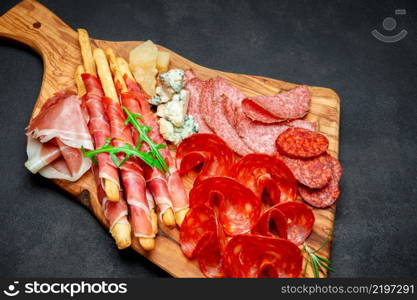 Cold smoked meat plate with pork chops, prosciutto, salami and bread sticks isolated on white background. Cold smoked meat plate with pork chops, prosciutto, salami and bread sticks