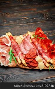 Cold smoked meat plate with pork chops, prosciutto, salami and bread sticks isolated on white background. Cold smoked meat plate with pork chops, prosciutto, salami and bread sticks