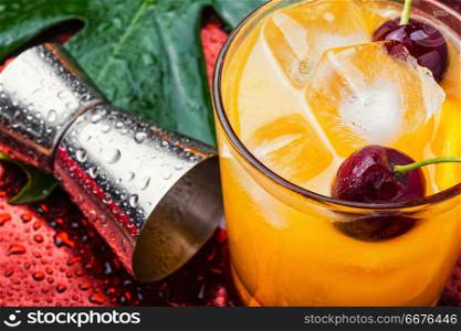 Cold summer drink with orange.Cocktail.Orange juice with ice. Orange drink with cherry