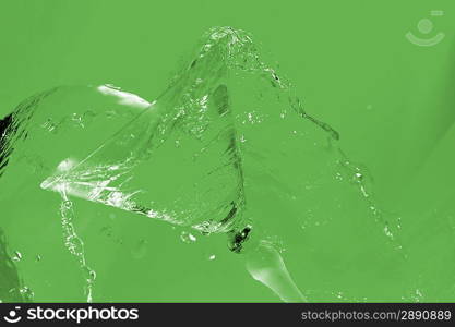 Cold transparent water in cocktail glass and splashes on yellow