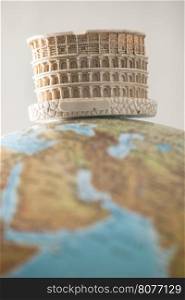 Coliseum of Rome on globe. Miniature concept
