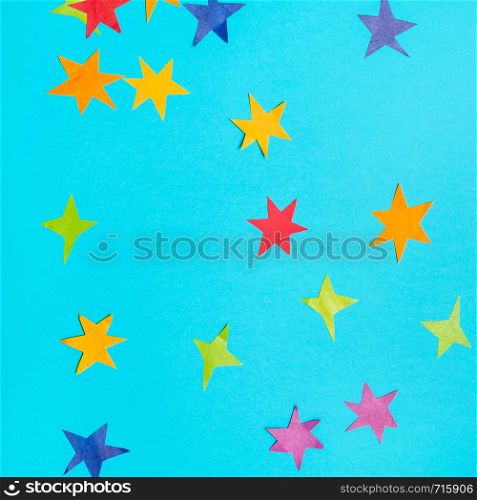 collage of stars cut from colored papers on blue turquoise pastel paper