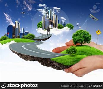 Collage with a human hand holding a green landscape