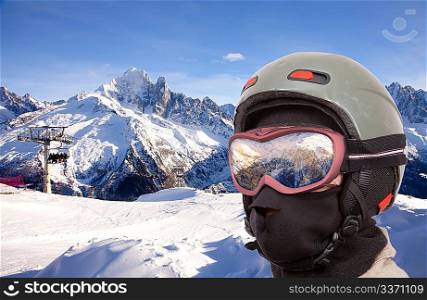 Collage with alpine slope and closeup skier in helmet
