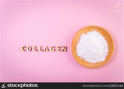 Collagen powder in wooden bowl on pink background. Natural bio supplement for skin, bone and joint health. Extra protein intake concept. Place for your text.. Collagen powder in wooden bowl on pink background. Natural bio supplement for skin, bone and joint health. Extra protein intake concept.