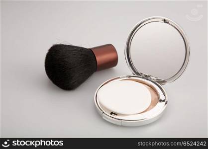 Collapsible mirror and brush for blush on a white background. Cosmetic set