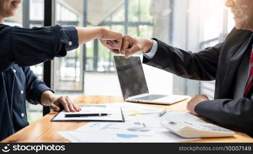 Colleagues Achievement Business Casual Fist bump together after dealing mission business, Business success and teamwork concept.