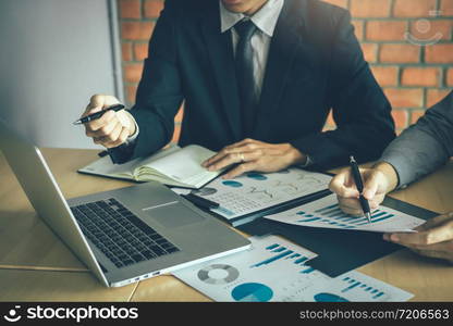 Colleagues are talking about the results in the documents on hand and compared with the financial information on the laptop screen.