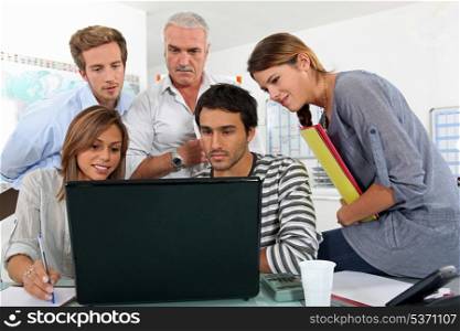 Colleagues behind a laptop