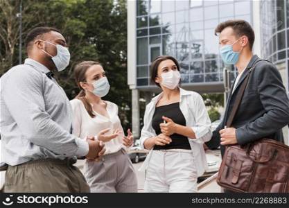 colleagues chatting outdoors during pandemic with face masks