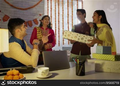Colleagues exchanging gifts with each other in office on the occasion of Diwali. 