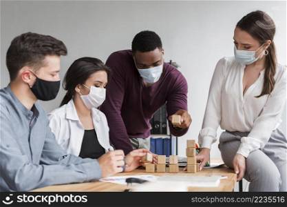 colleagues having meeting office during pandemic with medical masks
