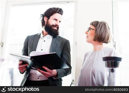 Colleagues in office, man holding book