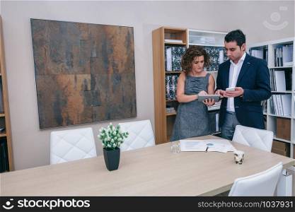 Colleagues looking document in electronic tablet on a business meeting. Business colleagues looking documents in electronic devices